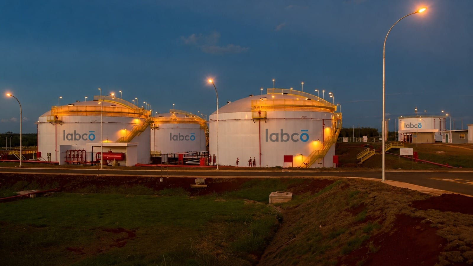 Labco-branded storage tanks lit at dusk at a tank terminal